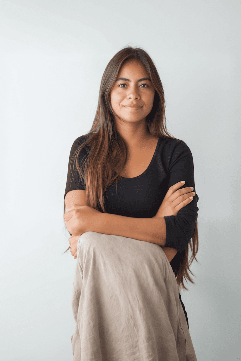 Portrait of a laughing person with curly hair wearing a white shirt